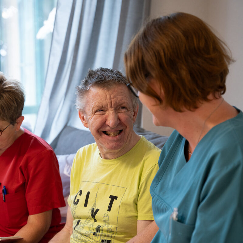 ein Bewohner lächelt eine Betreuerin an